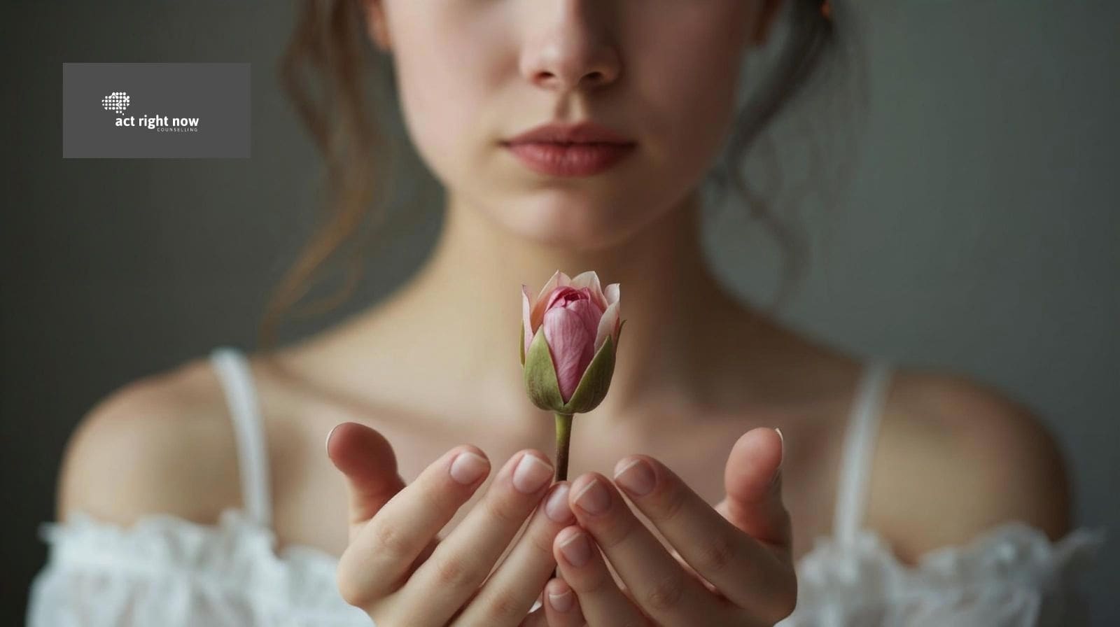 woman holding a flower that has to bloom